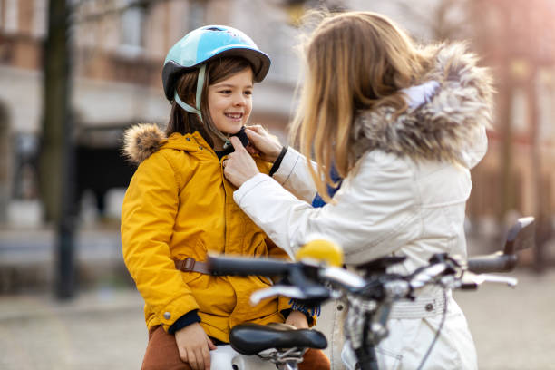 istock Mother putting bicycle helmet on her son 1202476308