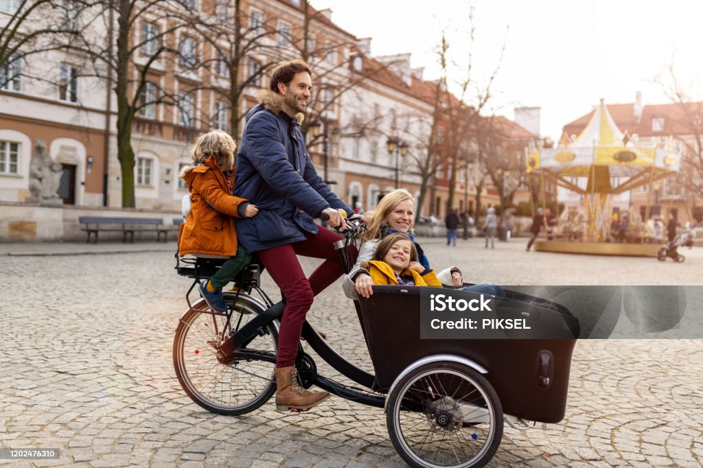 Young family enjoying spending time together, riding in a cargo bicycle Cargo Bike Stock Photo