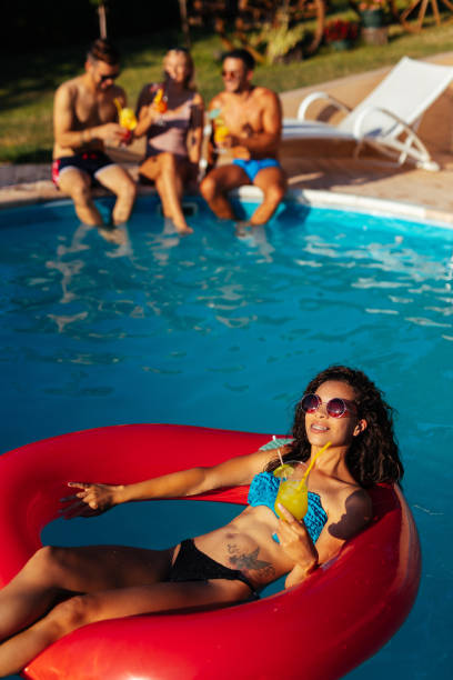 istock Playful friends hanging out at pool party 1202476554