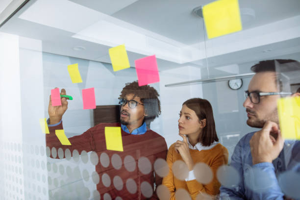 istock Business people brainstorming ideas behind glass wall 1202476699