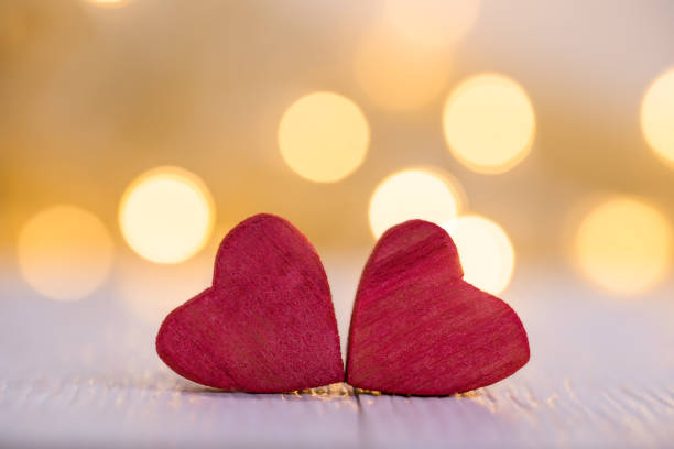 istock Valentine's day background with two wooden hearts on a table 1202477169