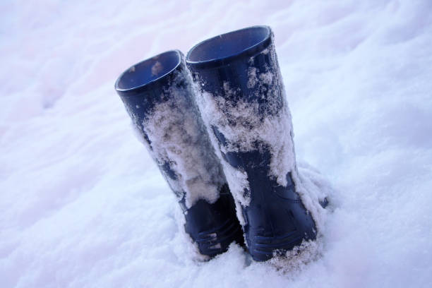 Blue wellies empty in snow stock photo