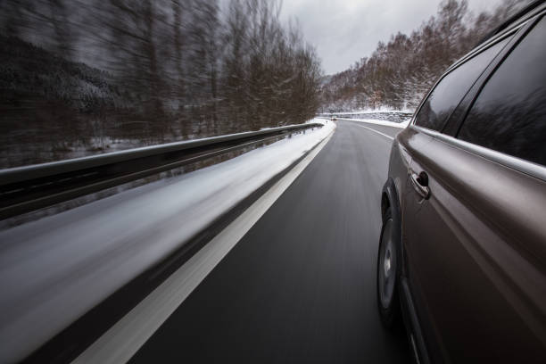 автомобиль на зимней альпийской заснеженной дороге - zoom blur стоковые фото и изображения