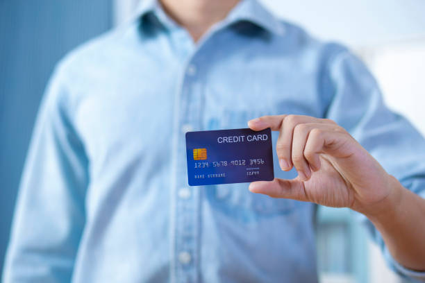 istock Man hand holding front credit card wear shirt 1202482110