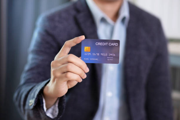 istock Man hand holding credit card wear suit jacket 1202482140