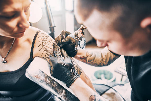 istock Tattoo Artist making a tattoo on a shoulder 1202482438