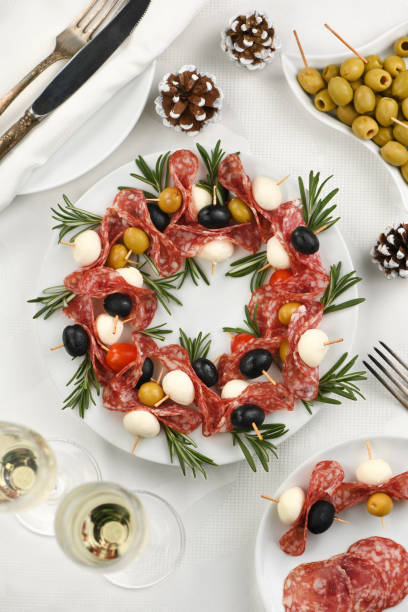 weihnachtskranz - antipasto. salami-kanapees mit oliven, baby-mozzarella. - salami sausage portion decoration stock-fotos und bilder