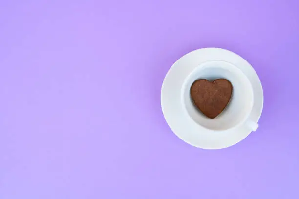 Coffee mug on a purple background. background Breakfast, drinks and cafe menu concept - coffee cup on purple background, toplay flatlay. cookies to coffee. White mug. copy space.
