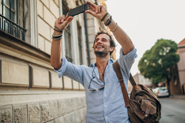 istock Hipster man photographing in the city 1202484111