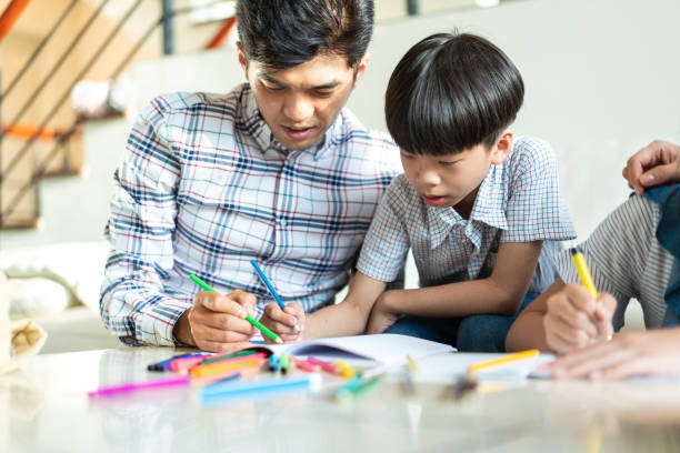 istock Father and son spending weekend together and drawing at home 1202484598
