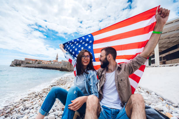 istock Young couple with USA flag on beach 1202485047