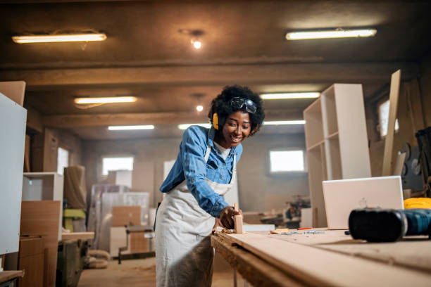 istock Carpenter girl working in a carpentry workshop 1202485953