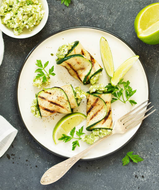 istock Zucchini rolls stuffed with cottage cheese and avocado. Snack. Selective focus. 1202485995