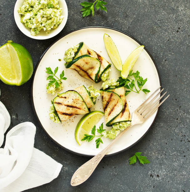 istock Zucchini rolls stuffed with cottage cheese and avocado. Snack. Selective focus. 1202487185