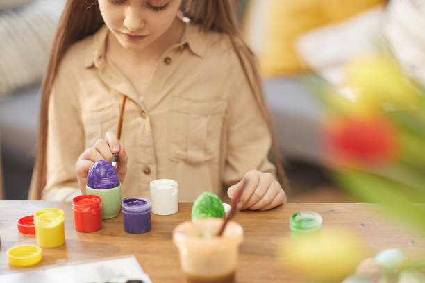 istock Girl painting eggs 1202488824