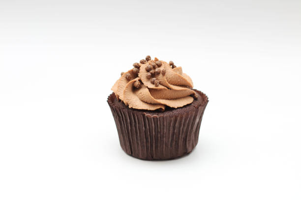 istock Isolated chocolate cupcake with cream top and crispy topping on a white background 1202489025