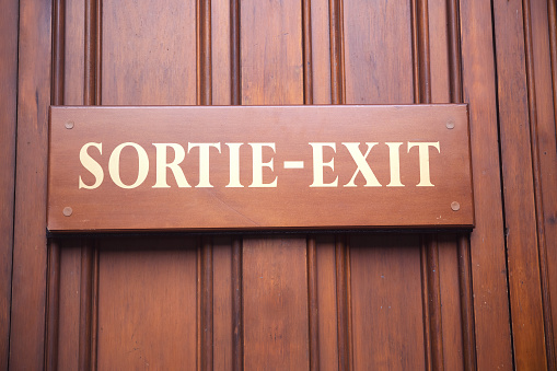 Wooden Plank displaying “Sortie-Exit” at the door