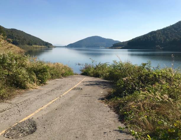 istock Road to placid lake between mountains, Thailand 1202490472