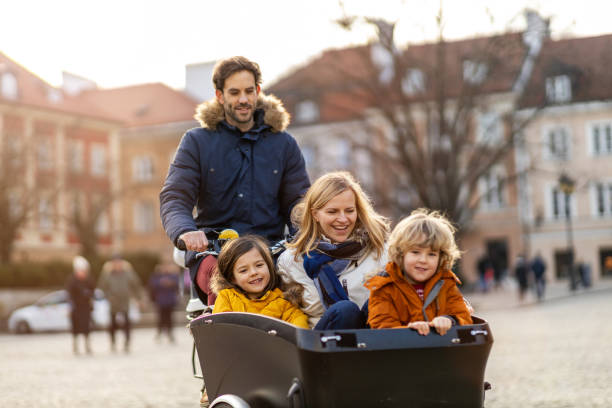 istock Young family enjoying spending time together, riding in a cargo bicycle 1202492068