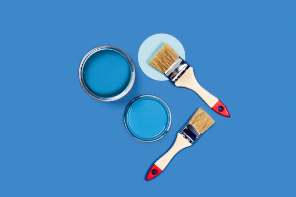 istock Brushes and pain cans on a blue background. 1202492302