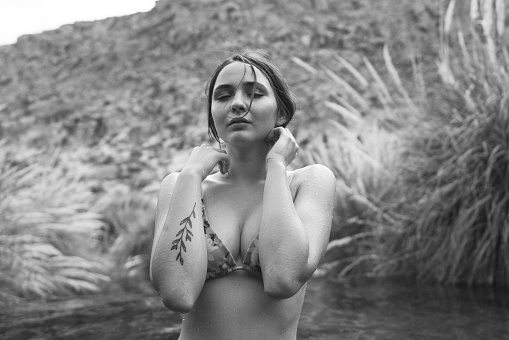 Young Caucasian woman swimming  in hot spring in Atacama desert