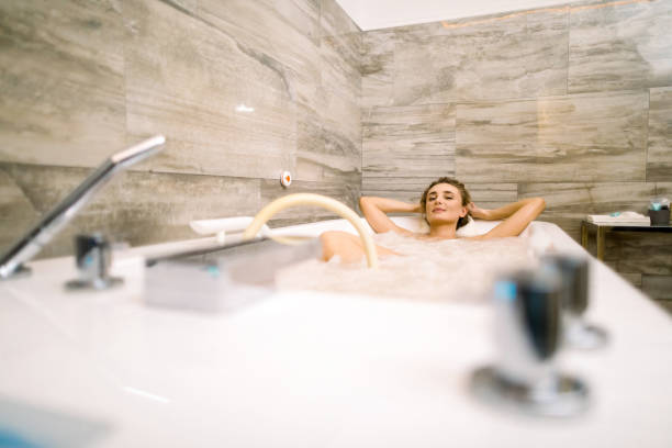 istock Young smiling woman lying in the bathtub while getting a hydromassage therapy in the spa clinic 1202498856