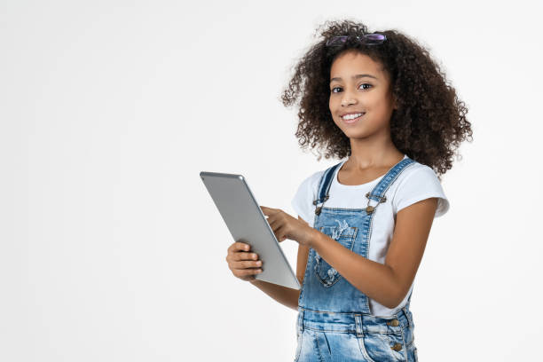 istock African preteen girl using tablet computer playing game isolated on white background 1202500300