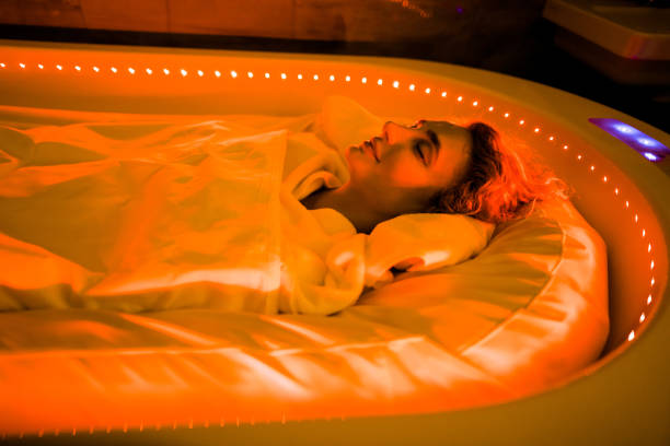 soins de la beauté, enveloppements du corps, capsule spa chaud dans le salon spa. jeune femme se trouvant dans le lit spécial de spa, couvert avec la couverture de thermo - hidromassage inside of wet luxury photos et images de collection