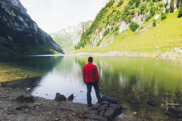 joven disfrutando de la mañana soleada de verano en el lago de montaña en los alpes suizos - switzerland hiking boot outdoor pursuit recreational pursuit fotografías e imágenes de stock