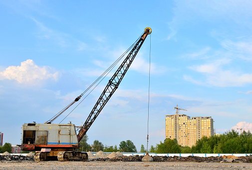 Tower cranes at construction site against sky background with copy space, full frame horizontal composition