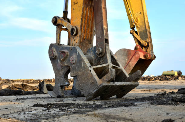 istock Excavator with hydraulic shears breaks asphalt on a construction site 1202503903