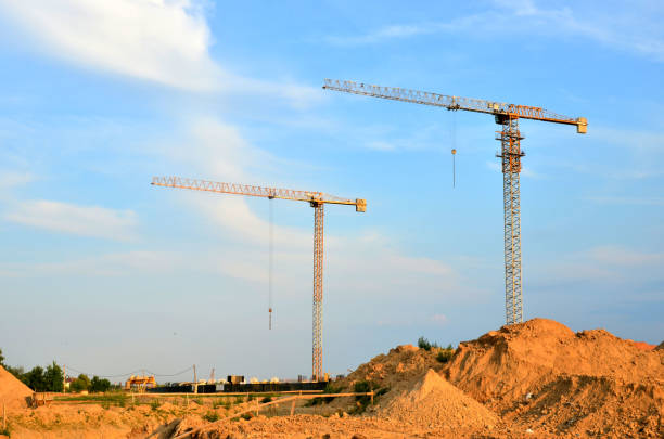 istock Jib construction tower crane at a construction site on the blue sky background 1202503929