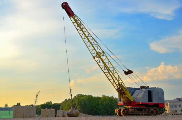 grande gru cingolati o escavatore dragline con una palla da demolizione in metallo pesante su un cavo d'acciaio - drag line foto e immagini stock