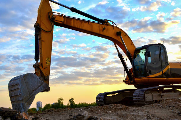 istock Excavator in a working at granite quarry on sunset background 1202505212