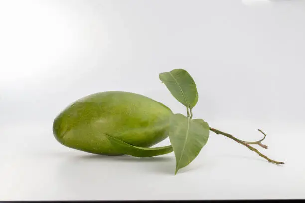 Photo of Delicious ripe mango with green leaf on white background.