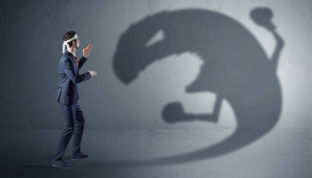 istock Businessman fighting with a big monster shadow 1202509281