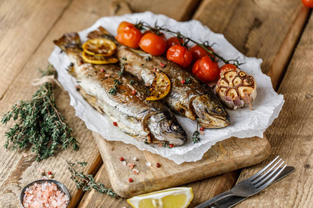 istock Cooked river trout with spices and ingredient for cooking on rustic background 1202510124
