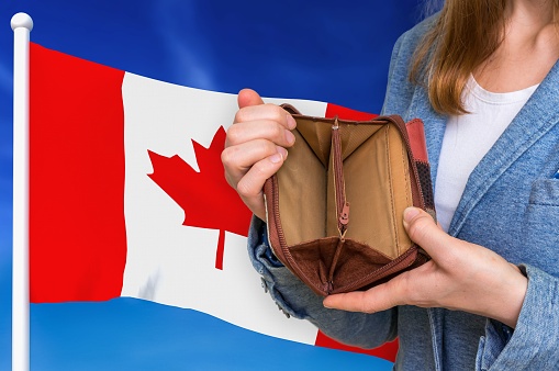 Finance problem in Canada. Poor person with empty wallet on national flag background.