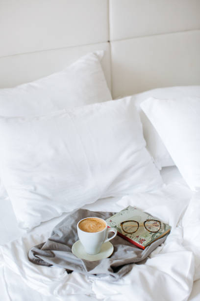 istock Cup of coffee and book in bed 1202511069