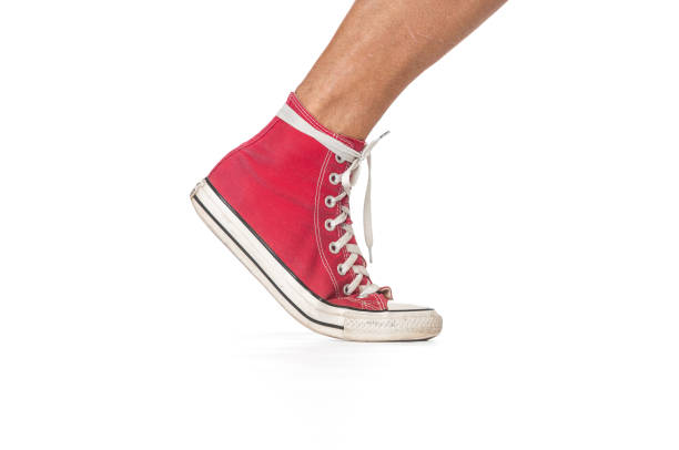 istock Running man`s leg in red sneaker on white background 1202511560