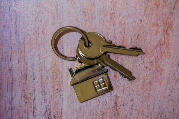 istock Two keys and a house-shaped keychain on the table 1202517469