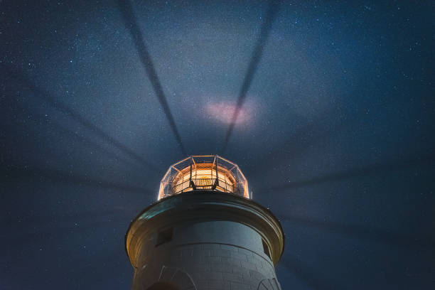 istock the sea lighthouse shines at night with bright rays of light 1202517620