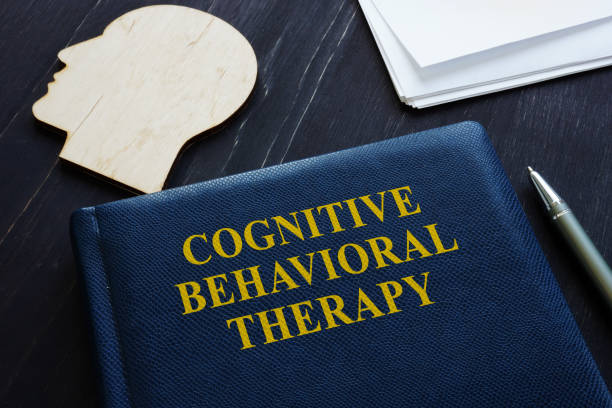 cognitive behavioral therapy cbt book and wooden head shape. - behavioral problems imagens e fotografias de stock