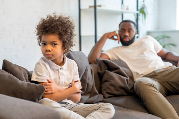 istock Upset child sitting and turned away from father 1202520208
