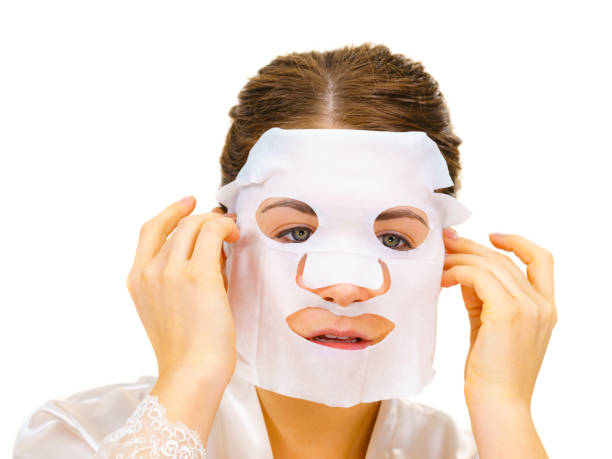 istock Woman applying sheet mask on face 1202520442