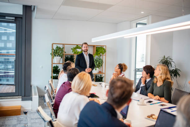 istock Young Businessman Giving Presentation to Colleagues 1202520799