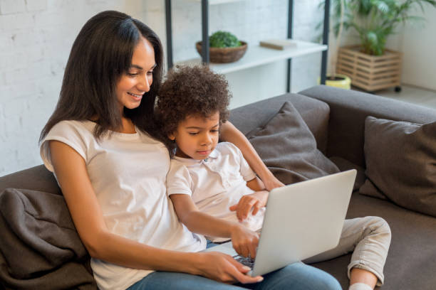 istock Happy pretty mother sitting with her son while using laptop 1202521337
