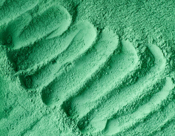 istock Green cosmetic clay powder (facial mask, face cream, body wrap) texture close up, selective focus. Abstract background with brush strokes. 1202522652