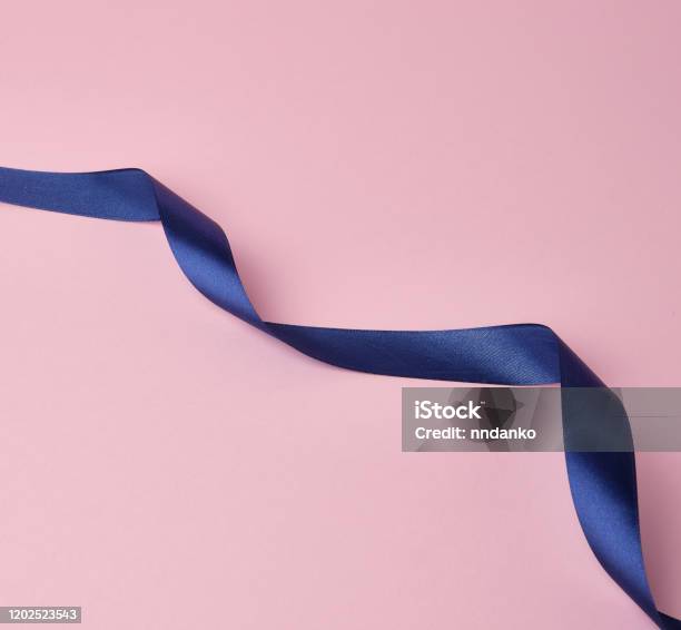 blue silk thin ribbon twisted on a pink background - a Royalty