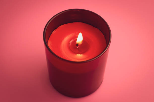 istock Red candle with flame on pink background. Aromatherapy, relaxation concept. 1202524237